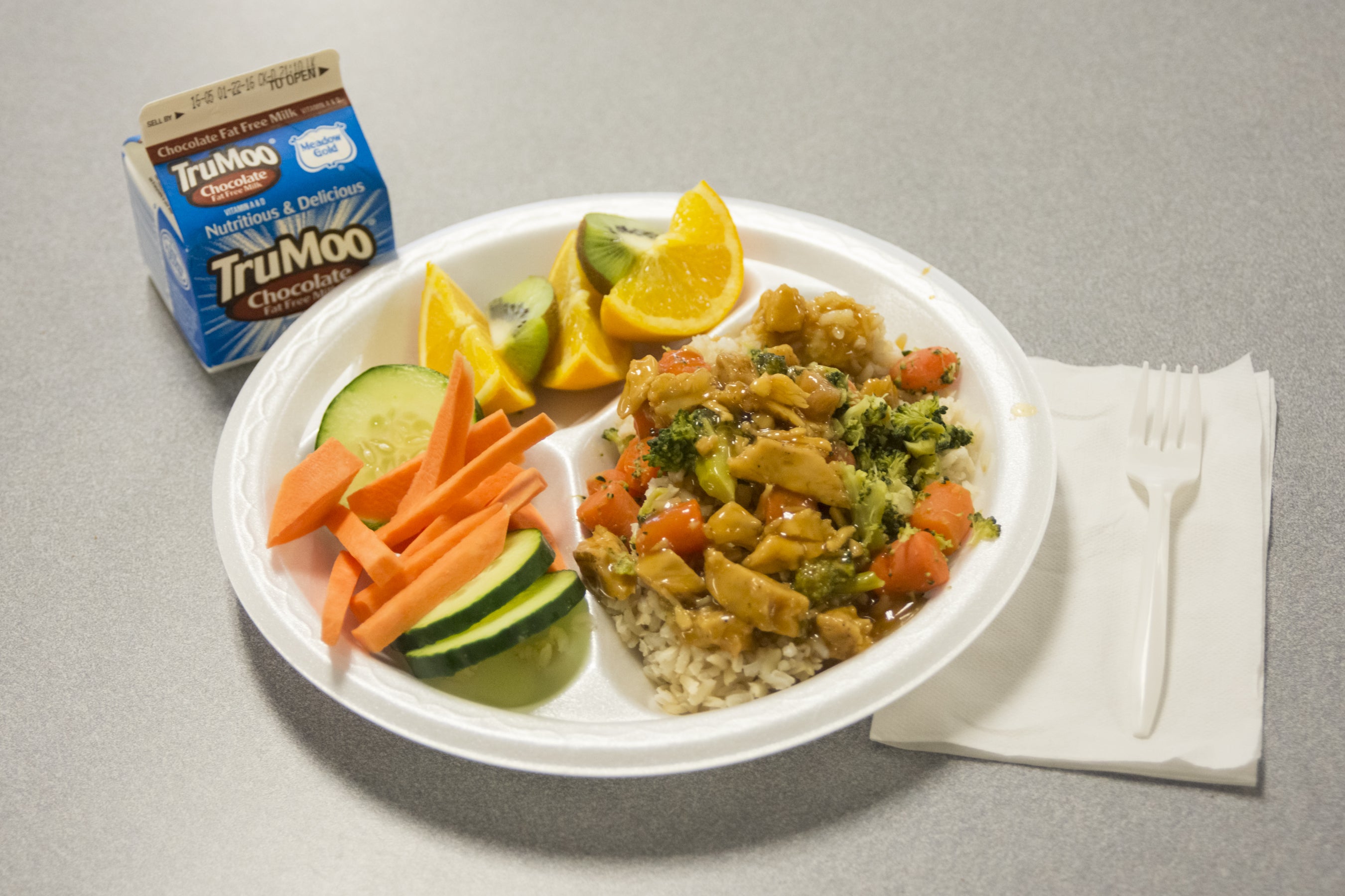 A rice dish with fruit and veggies on the side.