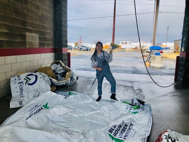 Alaina Holland at a wash station decontaminating lumber wrap.