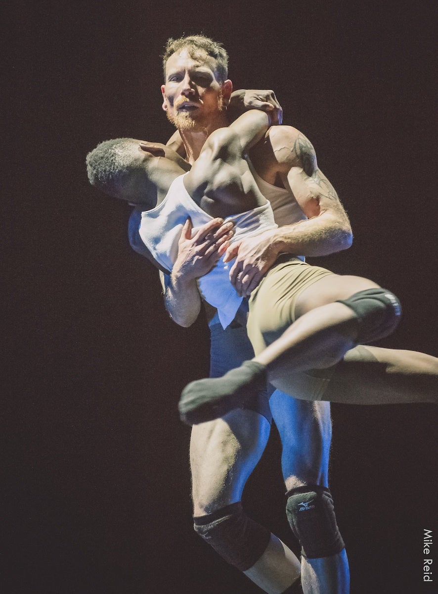Two dancers perform on stage.