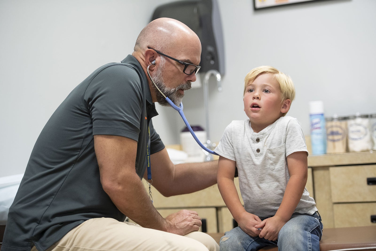 Max listens to a child's lungs using a stethoscope
