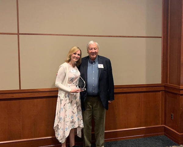 Dr. Merrick and Shandi Asher, holding an award. 