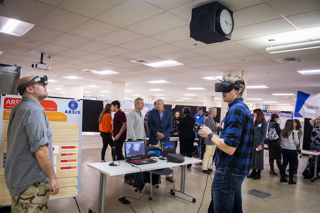 A student wears a virtual reality headset at the symposium.