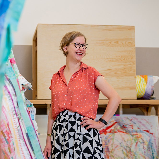 astri smiles beside her artwork