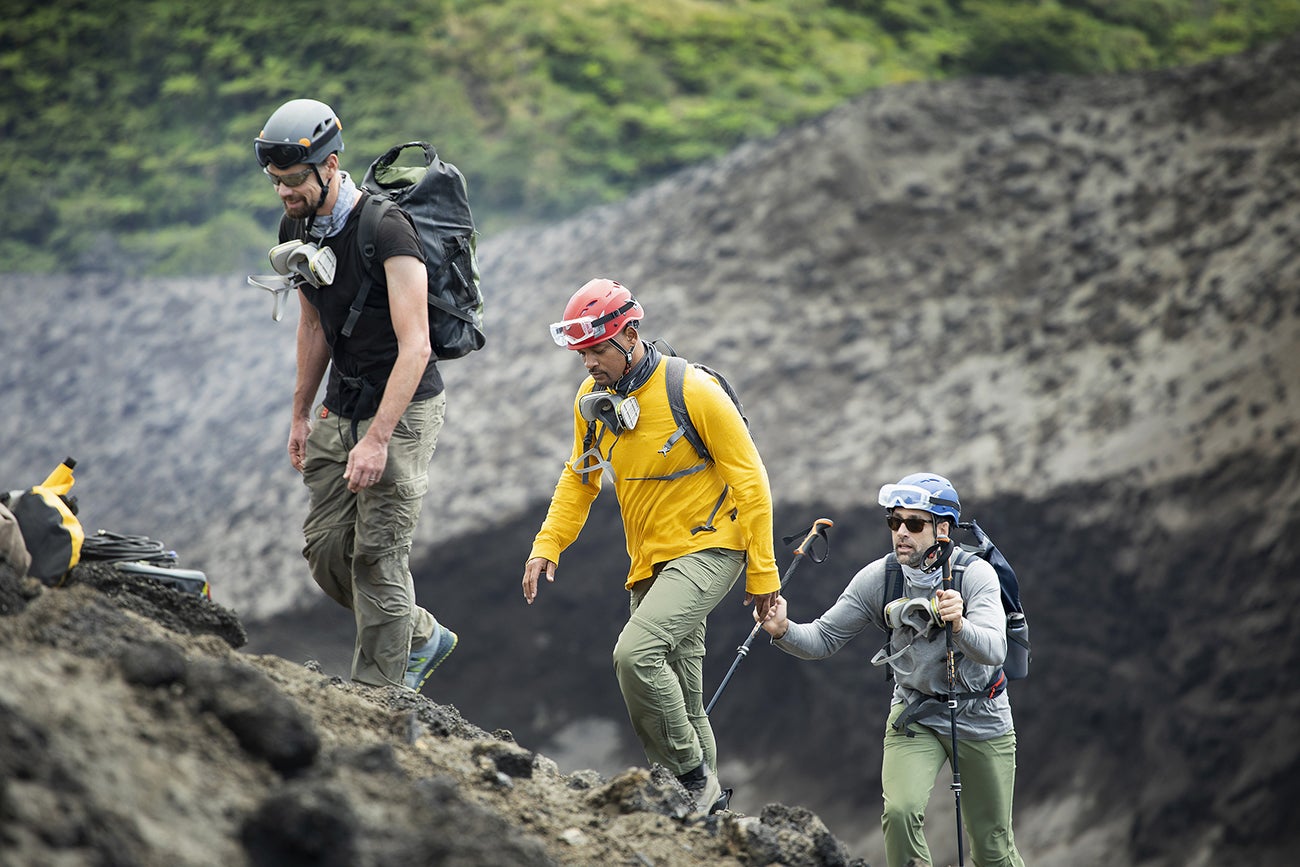 three men ascend a volcano