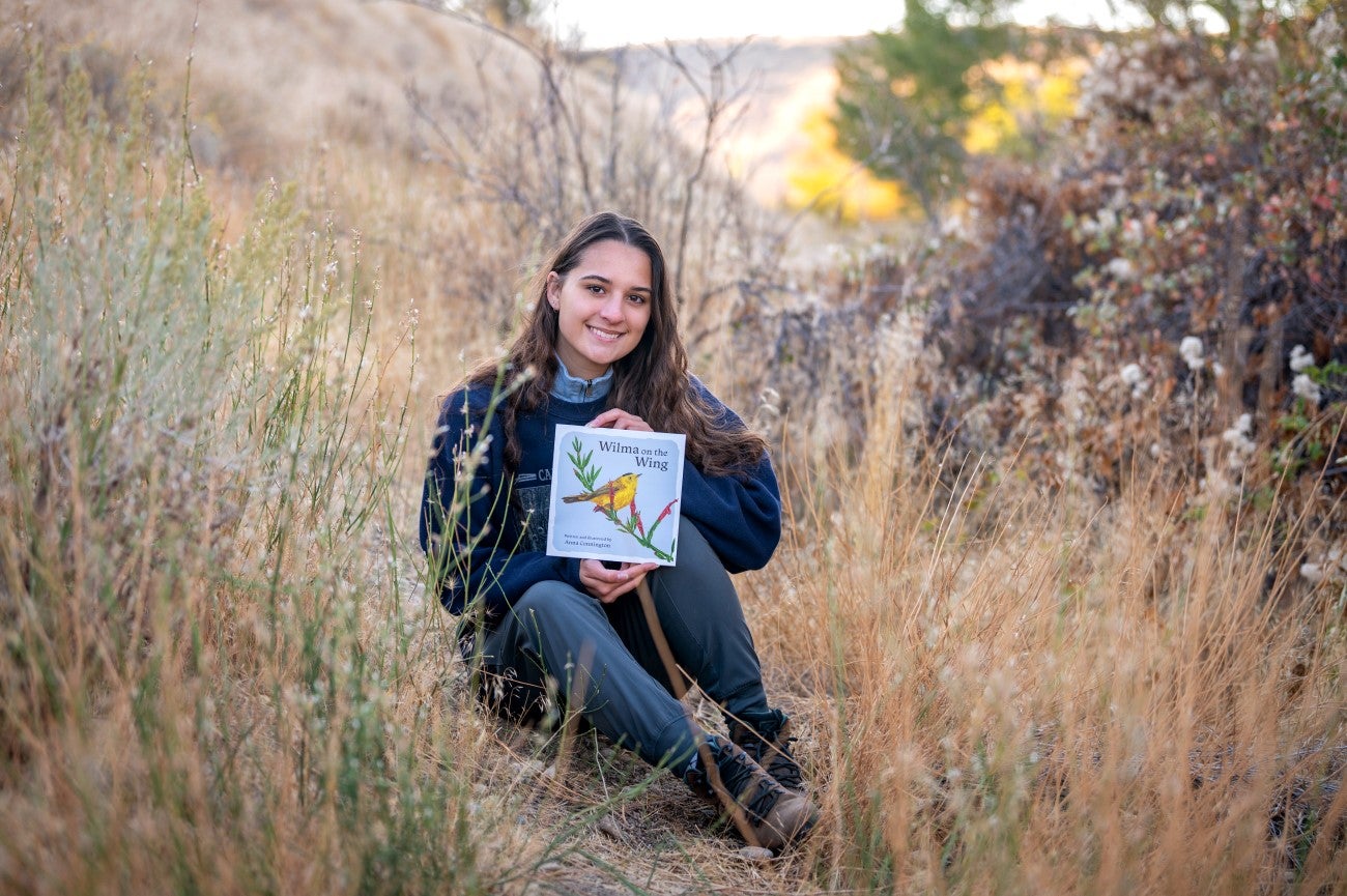 Anna Connington outside with copy of "Wilma on the Wing"
