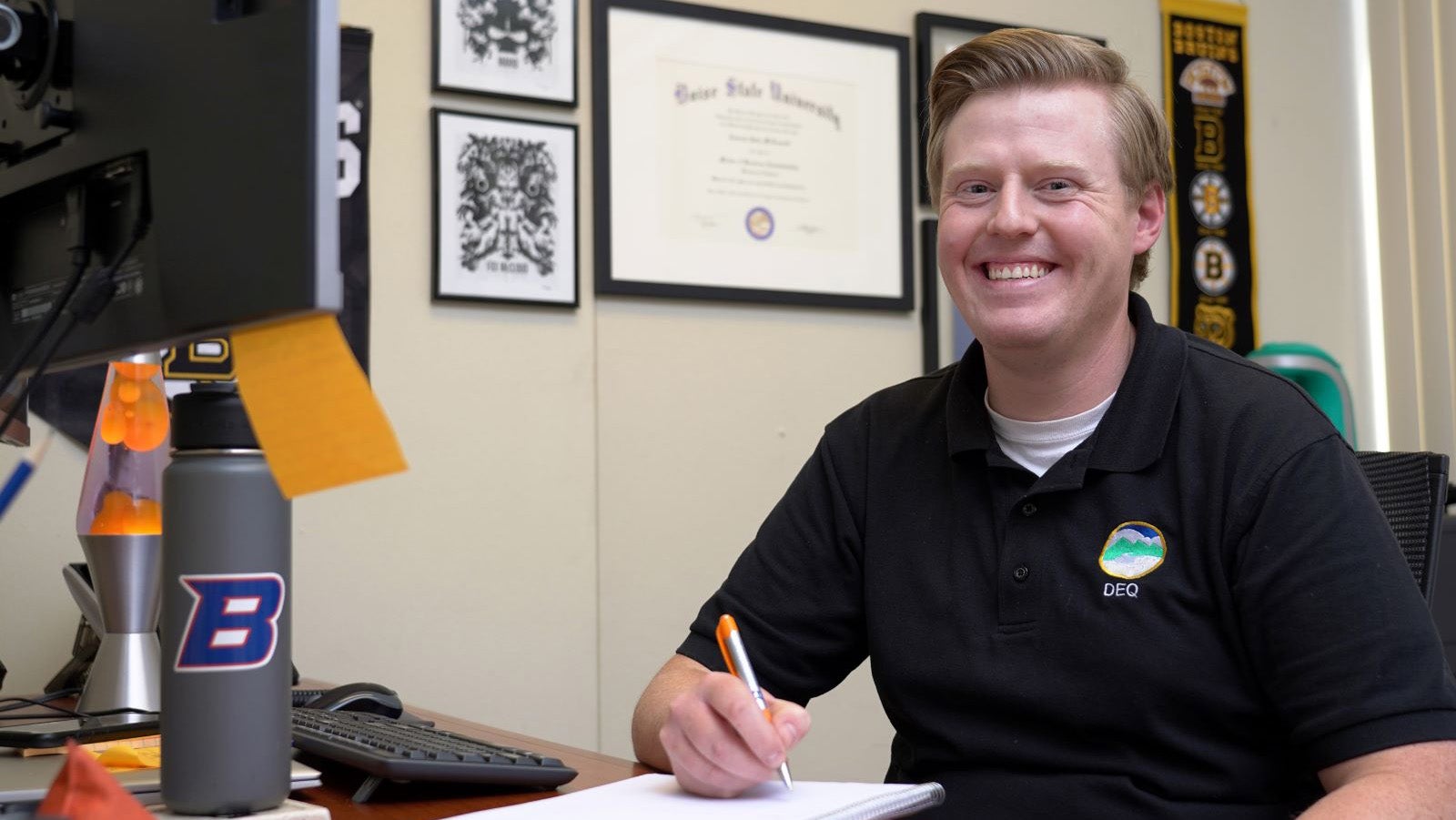 Andrew McConnell smiles while sitting at a computer desk