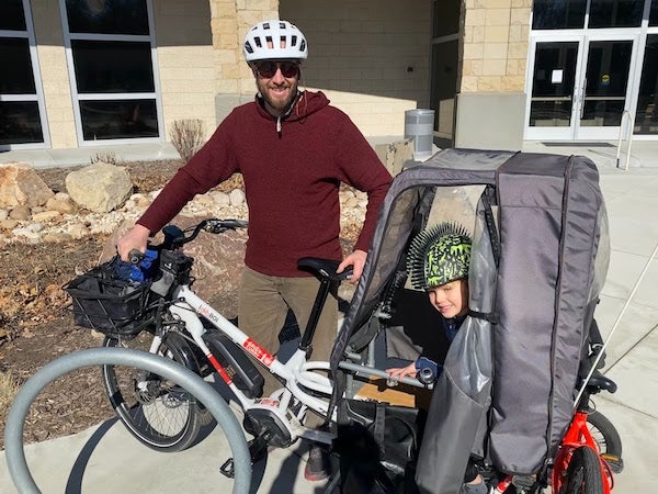 Man and child on an electric cargo bicycle