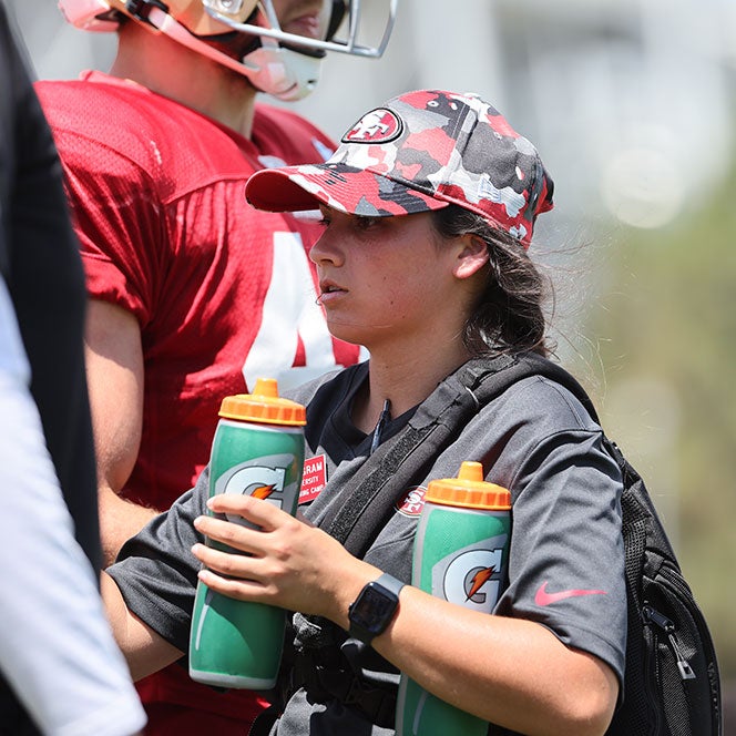 Sabrina Ingram-Rajan hands out waterbottles to San Fransisco 49er players