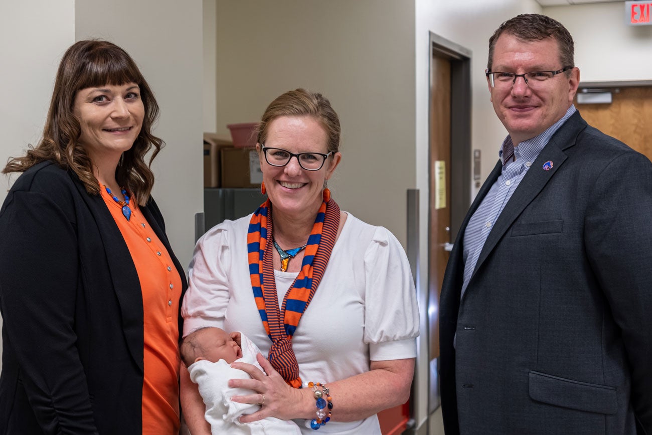 Kelley Connor holds a manikin baby and stands between colleagues Tracee Chapman and Jason Blomquist.