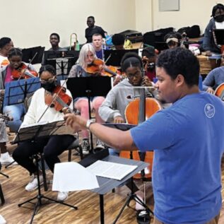 Kam JaCoby conducting student orchestra