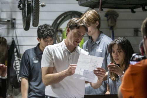 a man and and. young woman speak while looking at a piece of paper