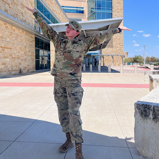 Cadet Kathryn Colburn poses in her uniform in from of the medical center at Fort Cavazos.
