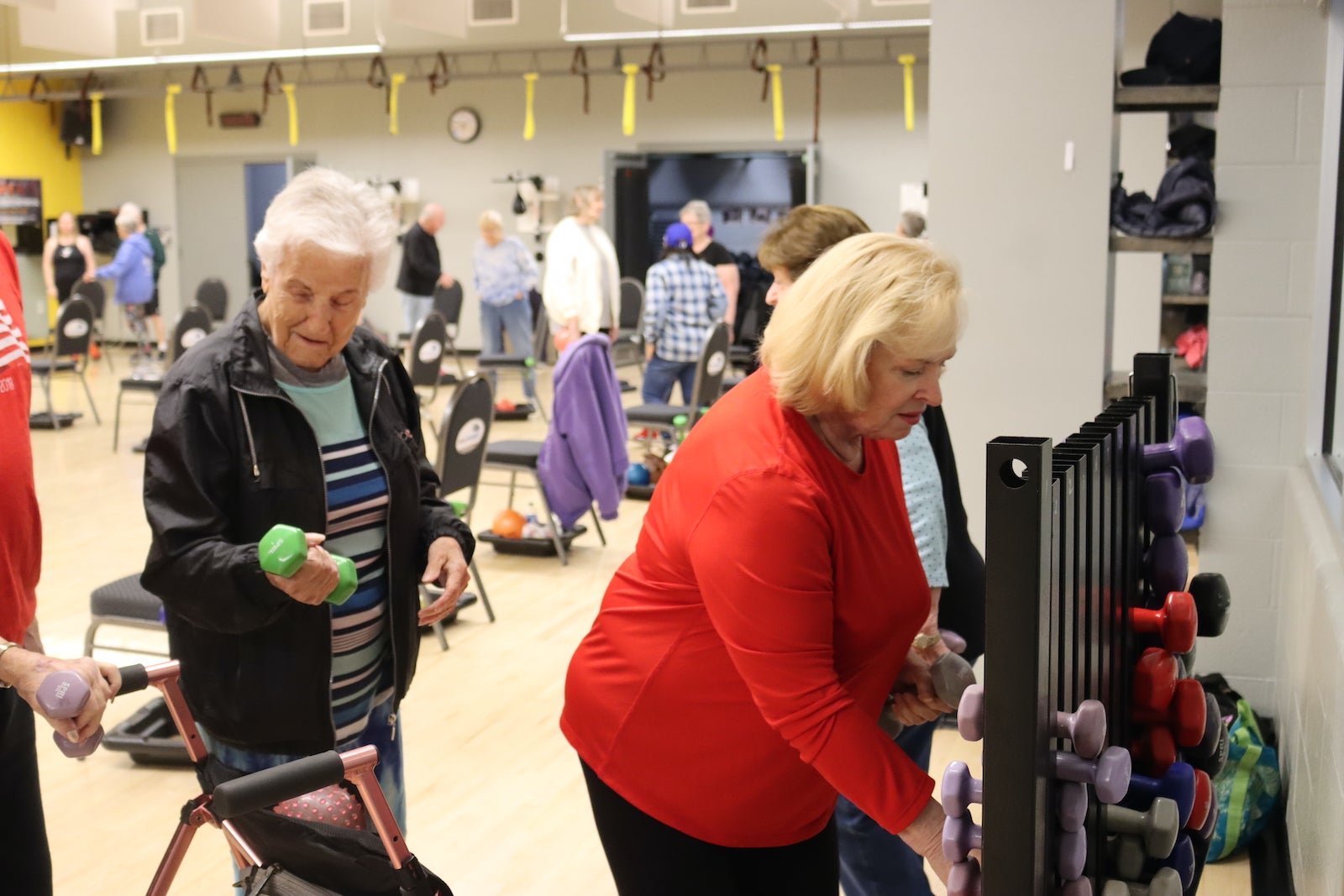 Elder women select free weights for exercise class