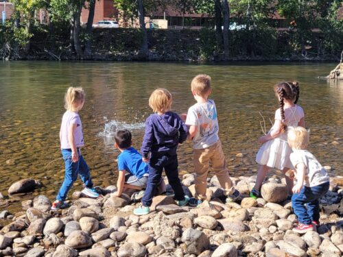 Six children play along the bank of the boise river.