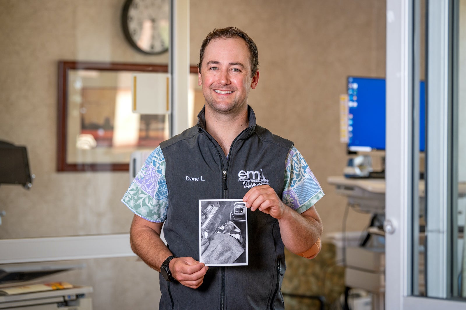 man in hospital holds photo of himself as a patient