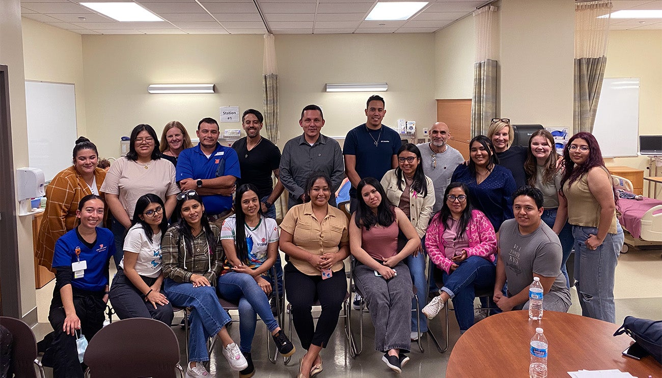 Participants in the global health ethics experience pose together for a photo in the School of Nursing.