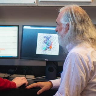 Greg Hampikian and a student look at genetic data on a computer screen. Photo by Zeke Hopkins.