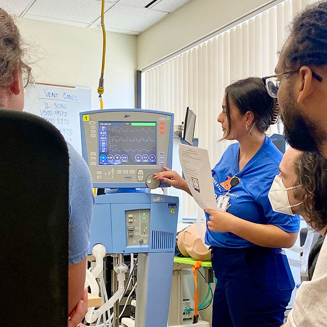 Natalie Tacher with Full Circle Health medical students explaining the ventilator settings