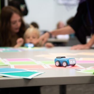 Teachers and children playing with toy cars