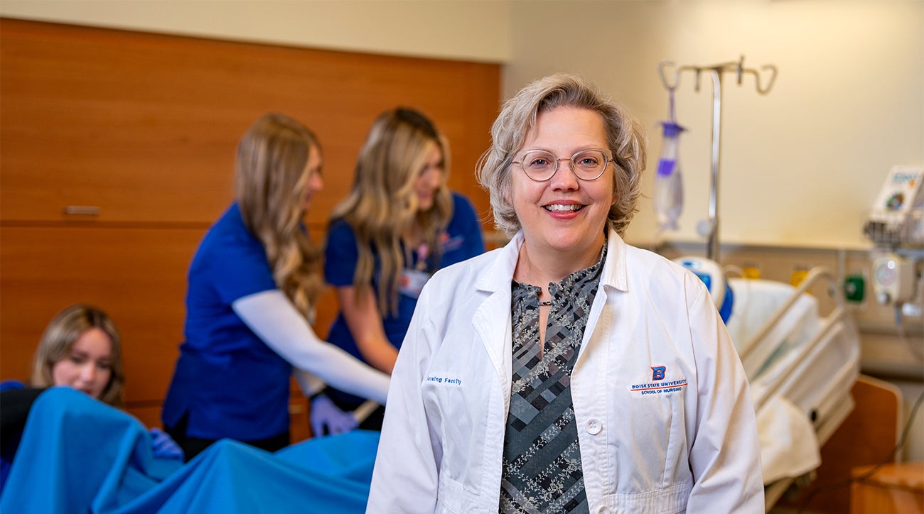 Amy Spurlock stands in front of nursing students working on a patient simlulation