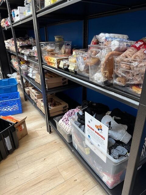 A bin of warm clothing accessories sits with food pantry items