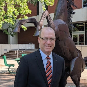 Andy Giacomazzi stands in front of Spirit of the Broncos stattue