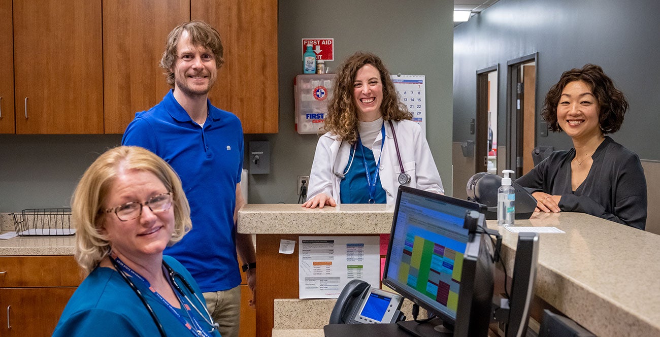 Health Services nurse, nurse practitioner, and counselors gather around the clinic's nurse's station