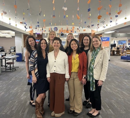 group of 8 women stand in group photo