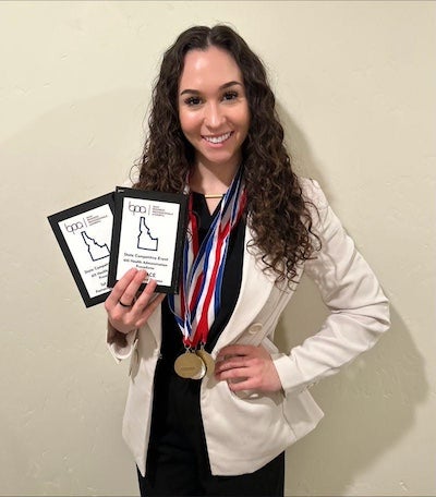 Photo portrait of Chase holding award plaques