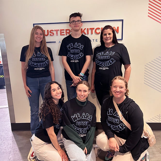 Six individuals pose together in their Special Olympics t-shirts.