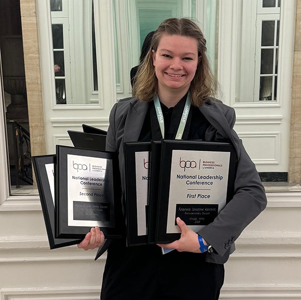 Allison Howard holding her awards