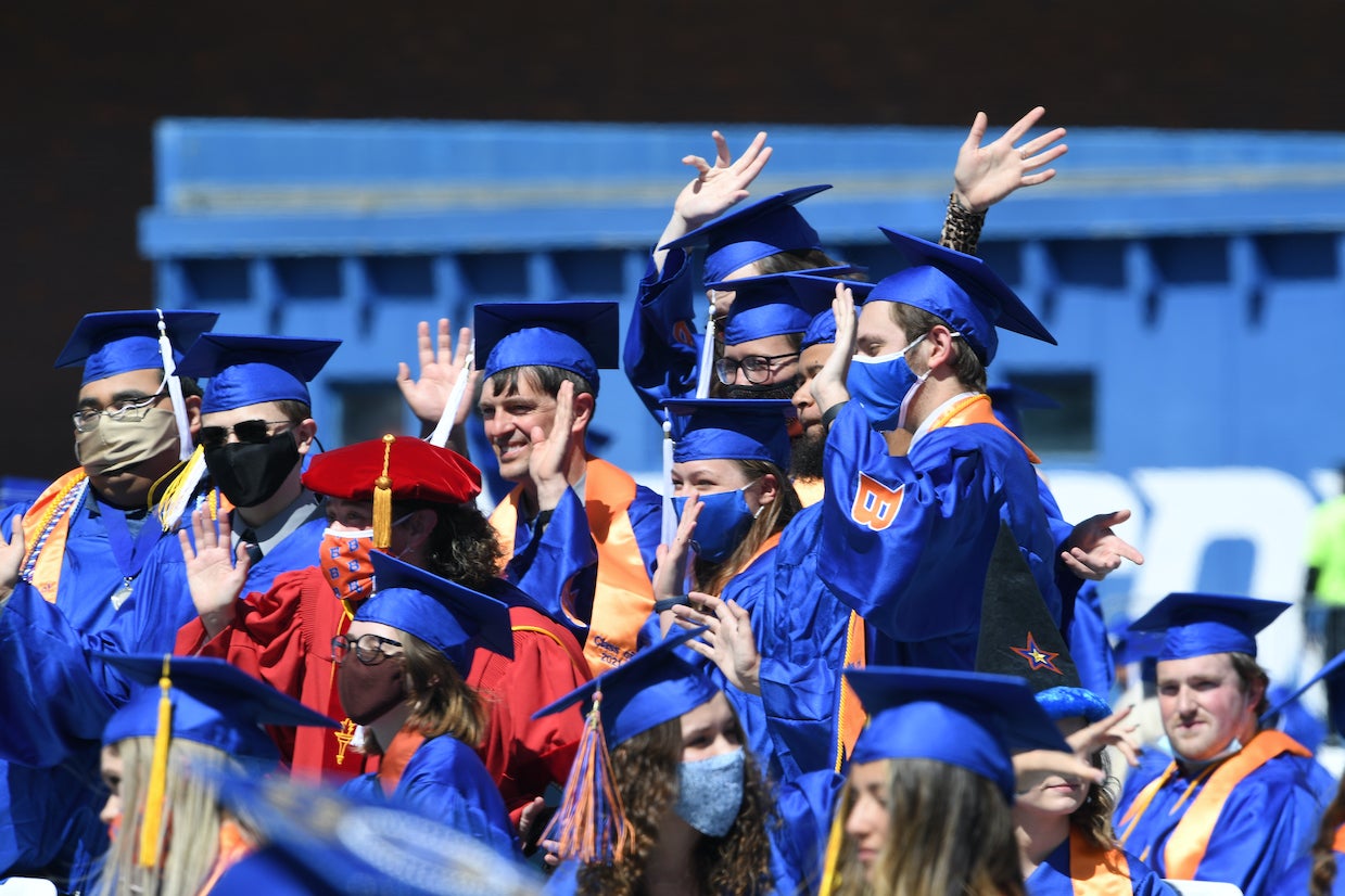 Graduates cheer at graduation.