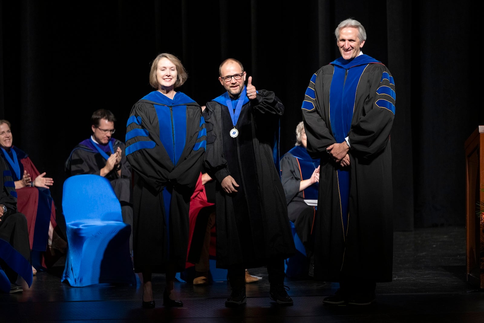 Sven Buerki on stage with other faculty.