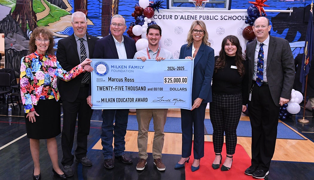 Persons pose with a novelty check