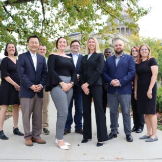 A group of persons poses at the Idaho Capitol