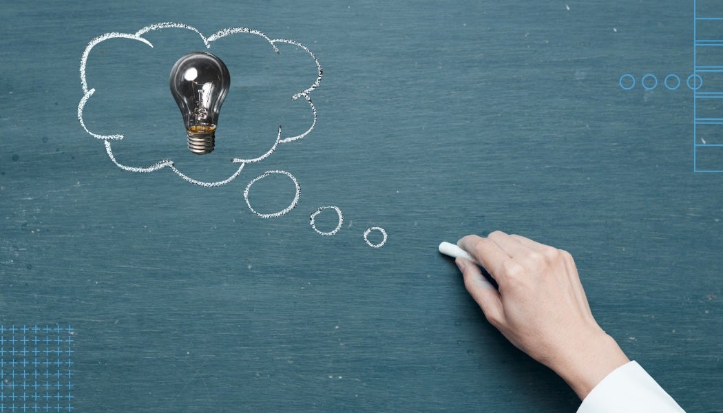 A person draws a though bubble on a chalkboard. Inside the bubble is an image of a lightbulb.