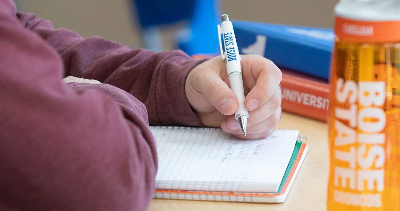 A close up of a person writing in a notebook