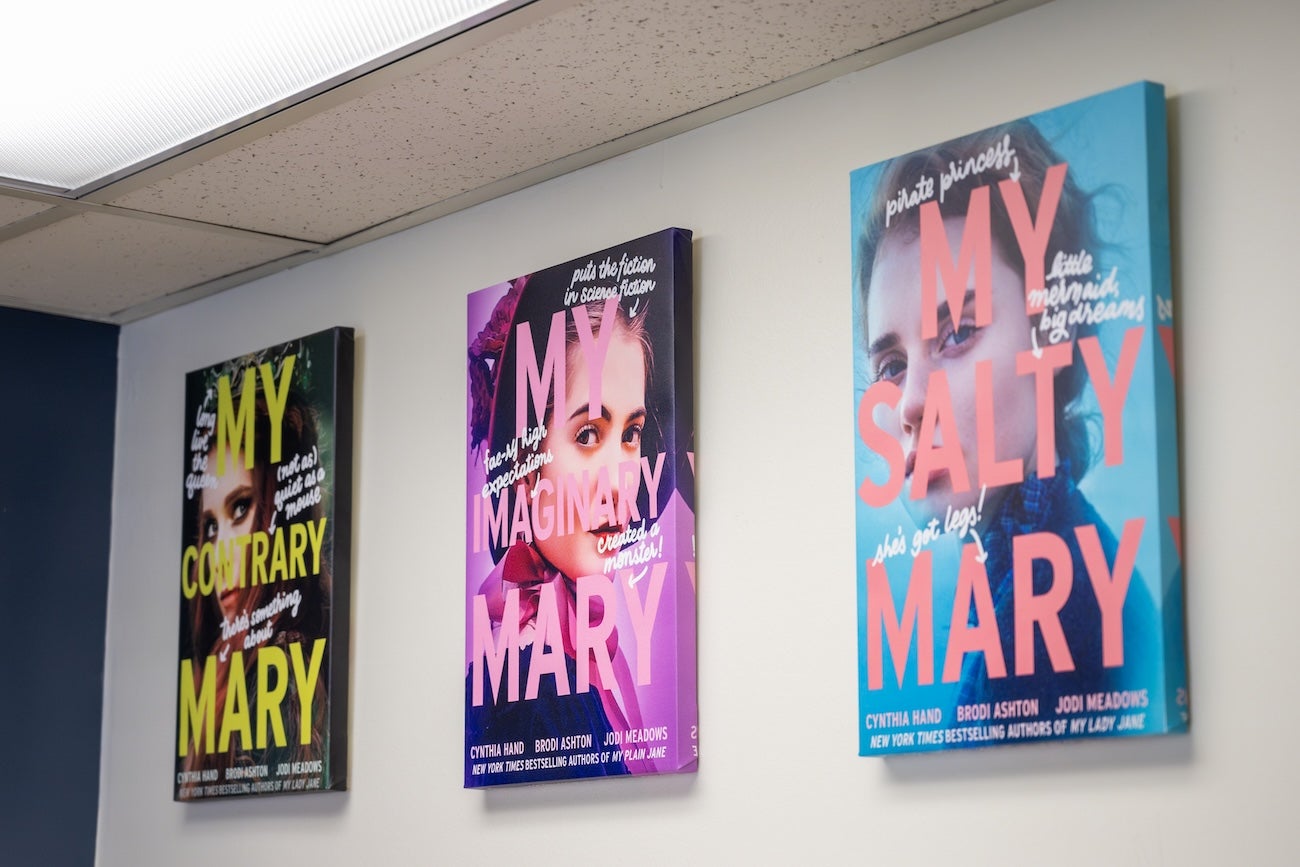 Book covers have been turned into canvas prints and hang on a wall. The titles are "My Contrary Mary," "My Imaginary Mary" and "My Salty Mary"