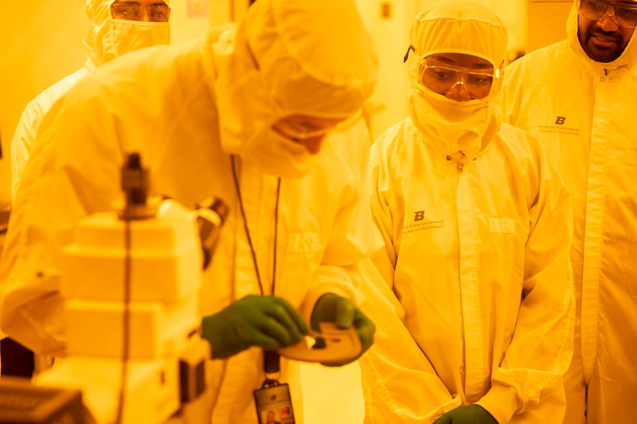 Persons in protective gear in a lab