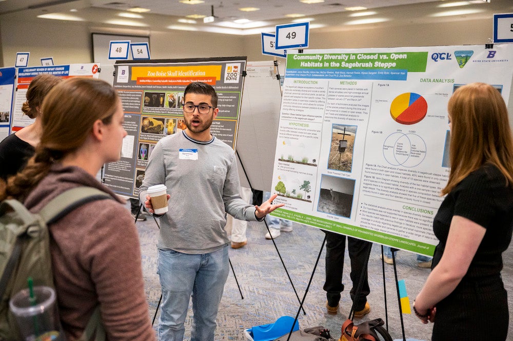 A person explains their research poster