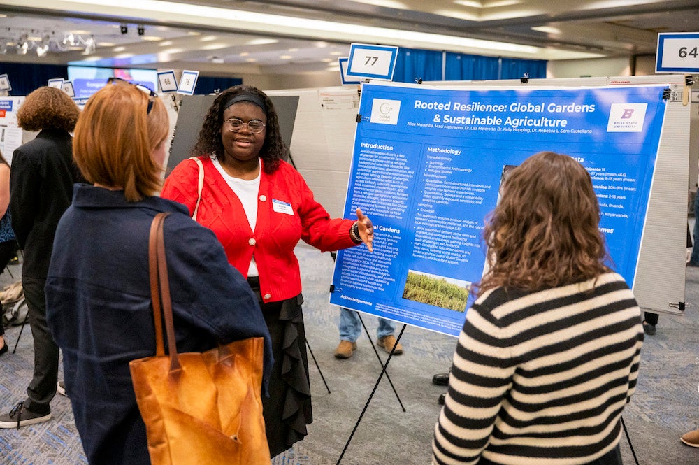 A person explains their research poster