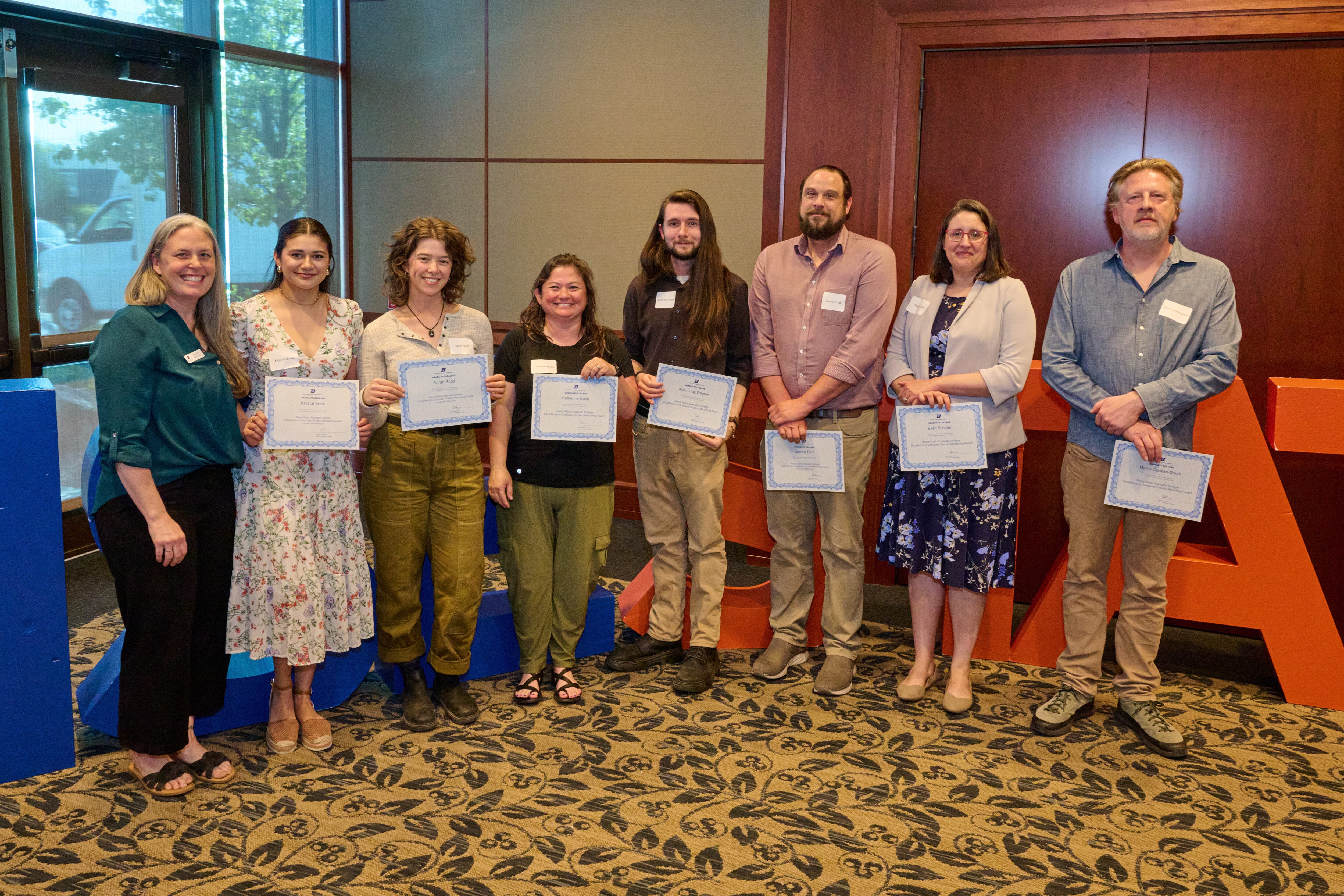 Persons pose with award certificates