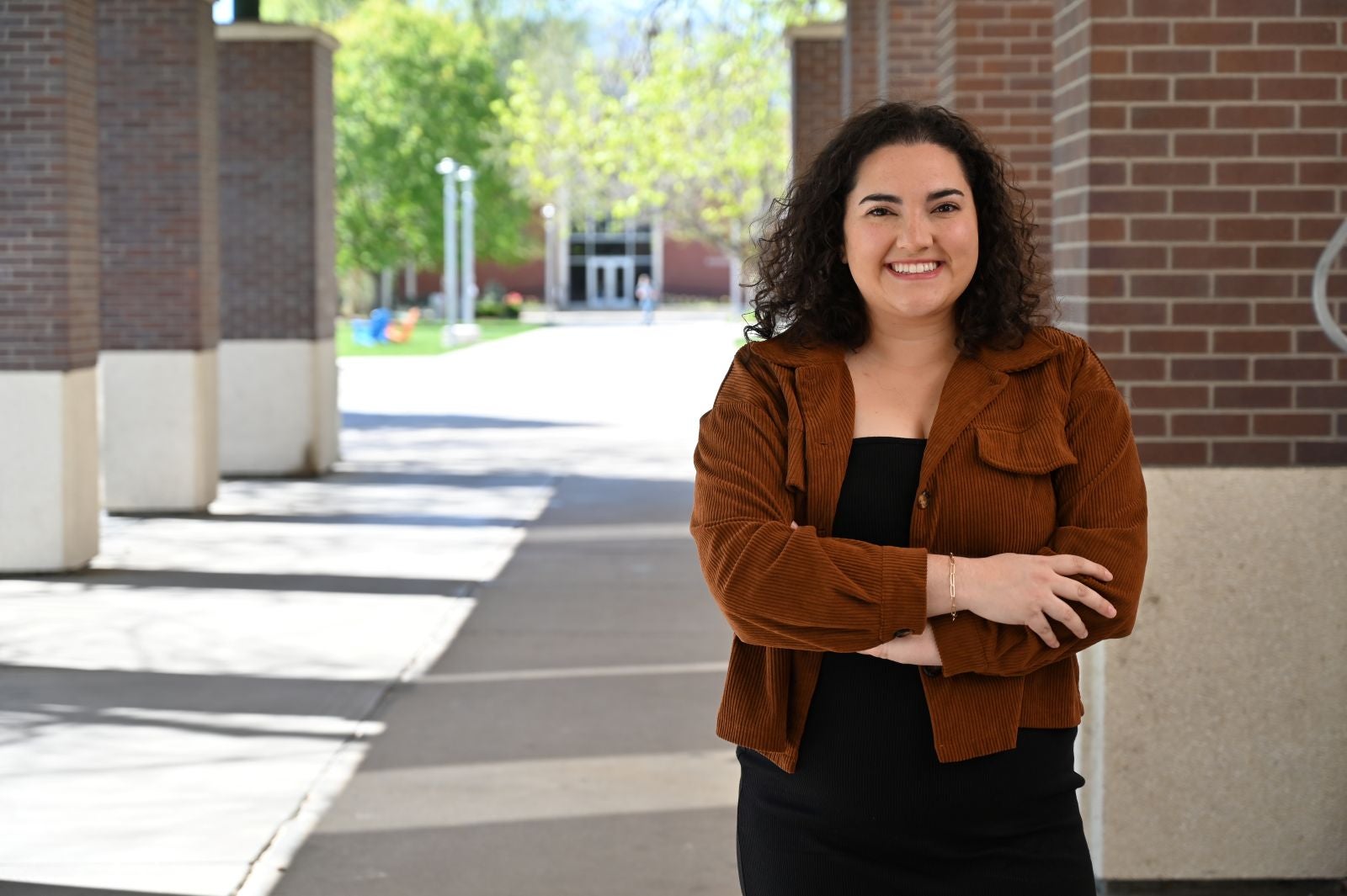 Boise State MA in Anthropology student Hallie Shean posing for a photo outside the Albertsons Library