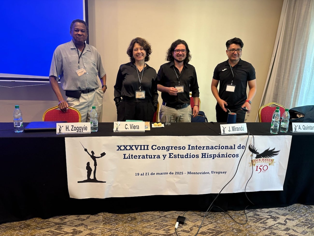 A panel of four persons present at a conference