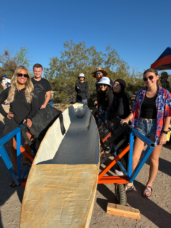 Seven students pose with their concrete canoe