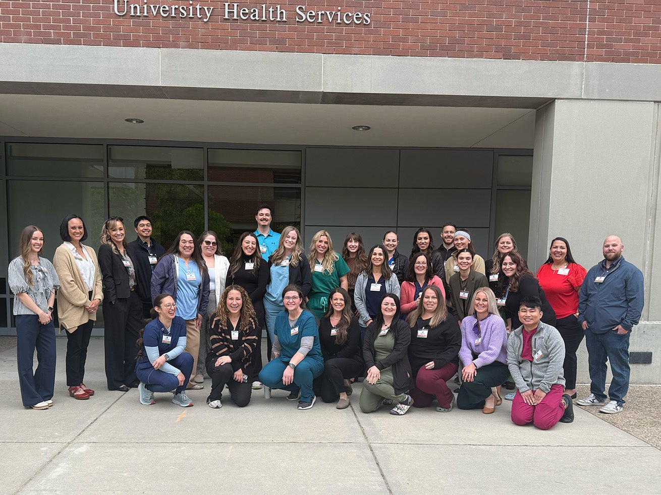 Twenty-nine graduate nursing students pose for a group photo in front of the Norco Building at Boise State.