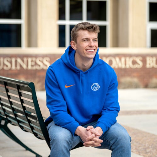 Nick Lloyd sitting on bench outside of business building.