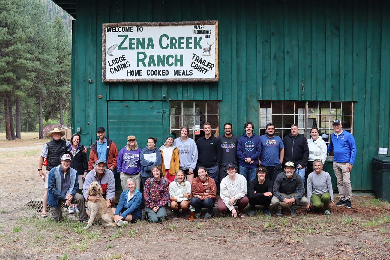SPS students and faculty posing in front of Zena Creek cabin.