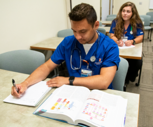 Student with open book taking notes