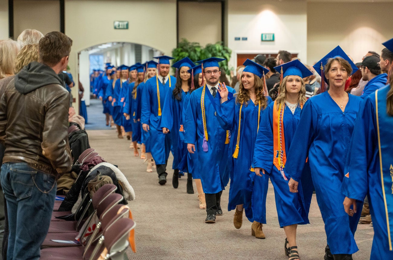 Onlookers clap for the nursing graduates walking into the ceremony.